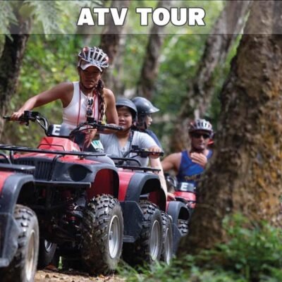 atv tour big buddha temple showing several riders on atv vehicles driving in single file on a dirt road through lush jungle with large trees