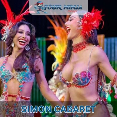 closeup of two smiling ladyboys posing in feathered outfits at Simon cabaret performance