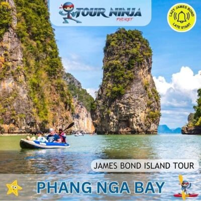 three canoes with tourists paddled by guides in Phang Nga bay showing impressive limestone cliffs