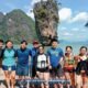 james bond island with a large group of asian people taking a group photo in front of the iconic island