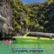 yellow speedboat moored in phang nga bay and tourists on kayaks in front of beautiful limestone cliffs