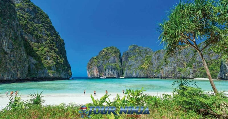 daytrip-phiphi-island-maya-bay-s16 maya bay phi phi island viewed from the beach with its beautiful white sand and turquoise sea and limestone rock formations