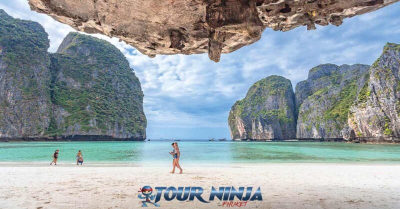 daytrip-phiphi-island-maya-bay-s6 maya bay viewed from maya beach standing under a limestone over hang it’s a beautiful view with a bright sunny sky