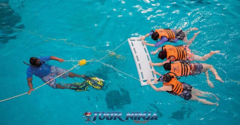 daytrip-racha-islands-snorkeling-s1 racha islands with a snorkeling guide supervising four snorkelers wearing orange life jackets and snorkeling gear