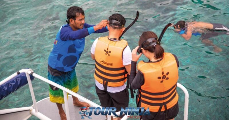 daytrip-similan-island-snorkeling-s5 similan islands daytrip with a tour guide and two customers wearing orange life jackets and snorkel sets ready to jump into the sea