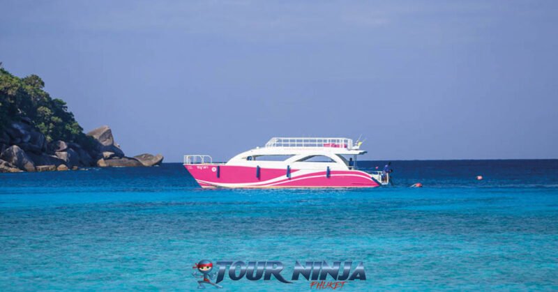 daytrip-similan-island-snorkeling-s9 similan island with a pink catamaran speedboat moored up on a beautiful bright sunny day with its crystal clear sea