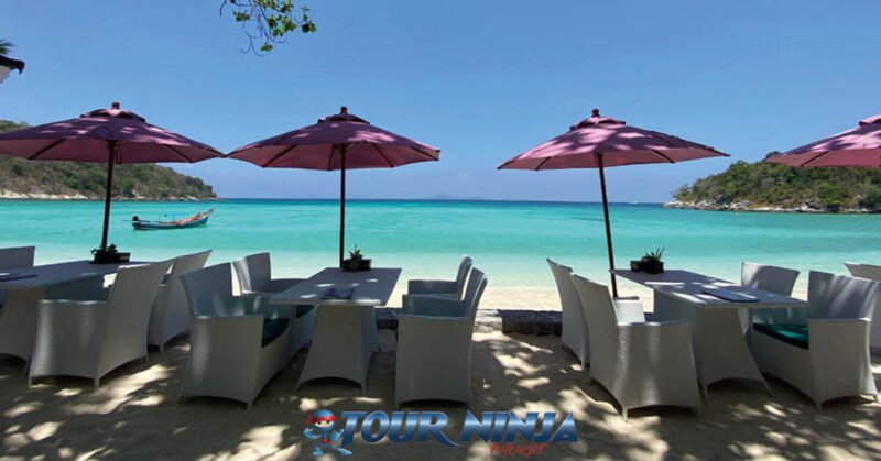 daytrip-snorkeling-racha-islands-s1 bungalow bay on racha yai island with some white rattan chairs and tables and purple beach umbrellas ready for customers to use