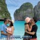 snorkeling tour visiting phi phi islands with two couples standing in shallow water inside maya bay kissing their partners