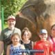 happy parents with three children posing in front of elephant at phuket sanctuary park