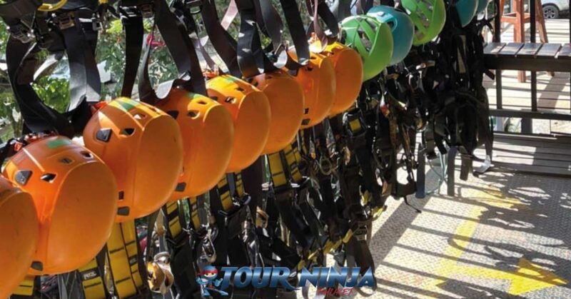 family-friendly-zipline-tours-phuket-pp2 family friendly zipline tour safety equipment hanging side by side with orange helmets and harnesses