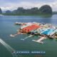 floating sea gypsy village in phang nga bay seen from above by drone shoot with multiple limestone cliffs in the background