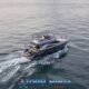 hype luxury cruising yacht underway shown from aerial view with white wake behind the sleek motor yacht in calm blue sea