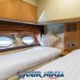 hype yacht double cabin showing two comfortable beds with pillows and white bedding and portholes to the side