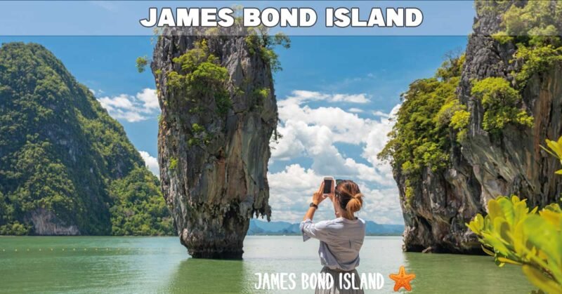 james bond island photographed by female tourist standing on a small beach in phang nga bay on a sunny day