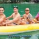 james bond island tour phuket with a group of three asian males and a tour guide paddling the yellow inflatable sea canoe