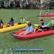 james bond island tour visiting phangnga bay with tourists sitting in their kayaks with tour guides paddling for them