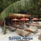 coral island kahung restaurant on beach with palm trees and umbrellas showing empty customer tables and chairs