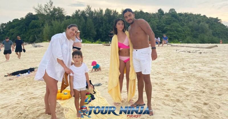snorkeling-island-hopping-phuket snorkeling tour with a family of four standing on a beautiful sandy beach posing for the camera