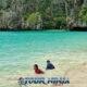 snorkeling tour phuket with a male watching over two kids playing in the shallow water in a small bay