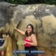 happy female visitor rubbing mud onto elephant in phuket nature park